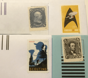 Four postage stamps on envelopes ready to mail